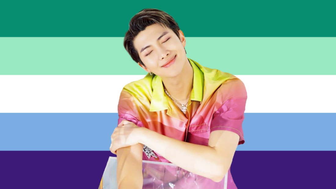 cutout of Namjun from seasons greetings 2020 in a sunset colored shiny shirt at a clear desk over the 5 stripe ocean gay flag