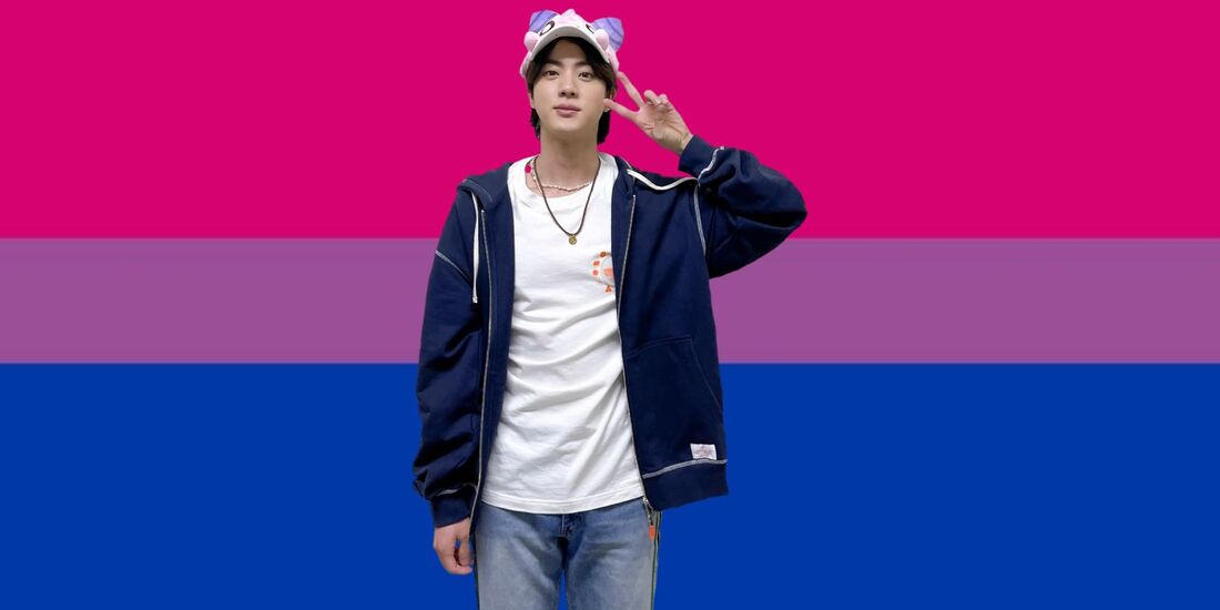 cutout of seokjin photo from twitter on march 10th 2022 after day 1 of the seoul permission to dance concert wearing a custom-made Pink Bean character hat and giving a peace sign by his face on top of the bi flag
